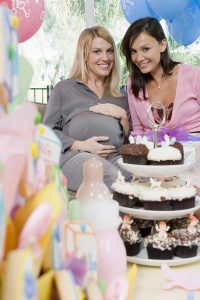 Femme enceinte avec gâteaux et cadeaux pour baby shower entre amis en Guadeloupe
